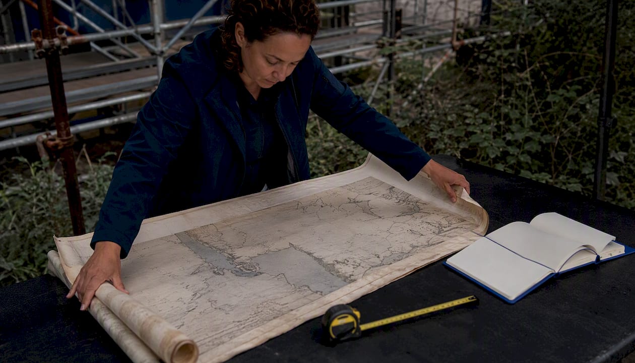 Environmental professional examining historical map outdoors
