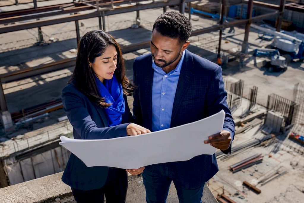 9 Loan Origination Efficiency Metrics Every Lender Should Track 9 Investors reviewing commercial real estate plans outdoors