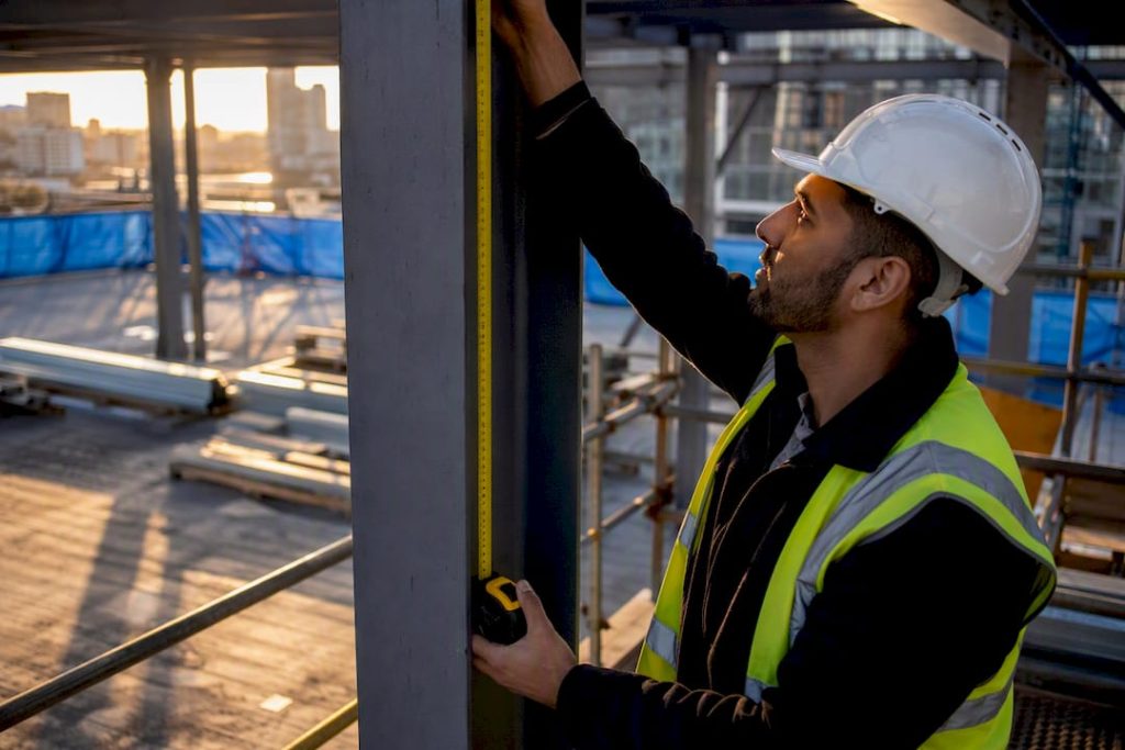 Real Estate Portfolio Diversification Types That Actually Work 5 Investor measuring construction wall at site