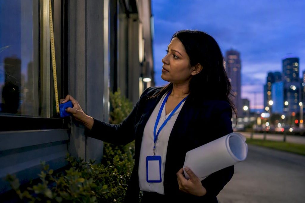 Investor measuring building facade outdoors